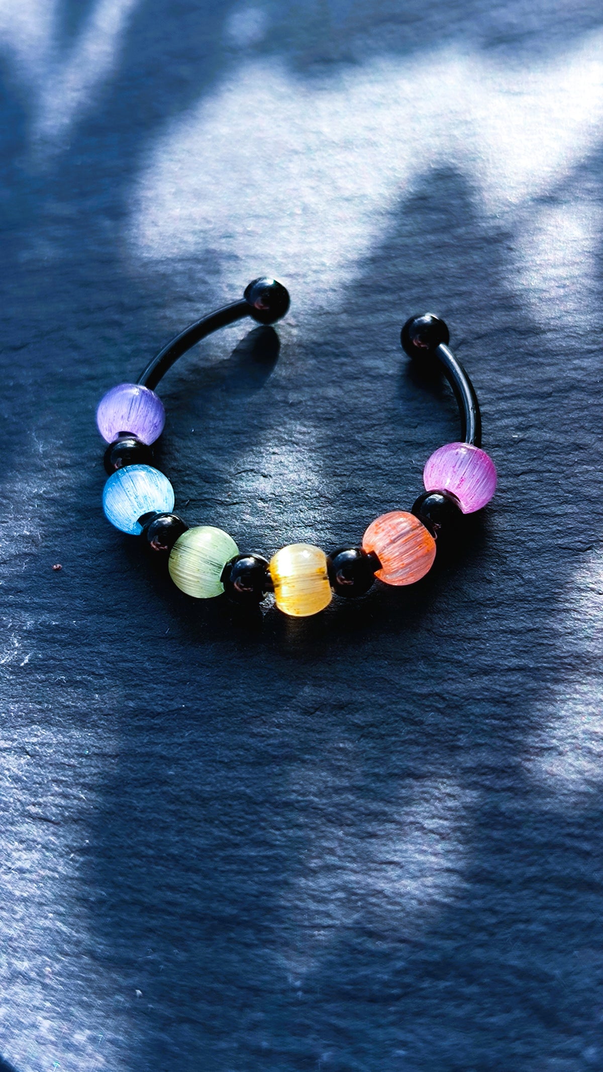 Schwarzer Anti-Stress-Ring mit Regenbogenperlen – größenverstellbarer Fidget Ring, limitierte Iris Black Edition von JoJos Presents
